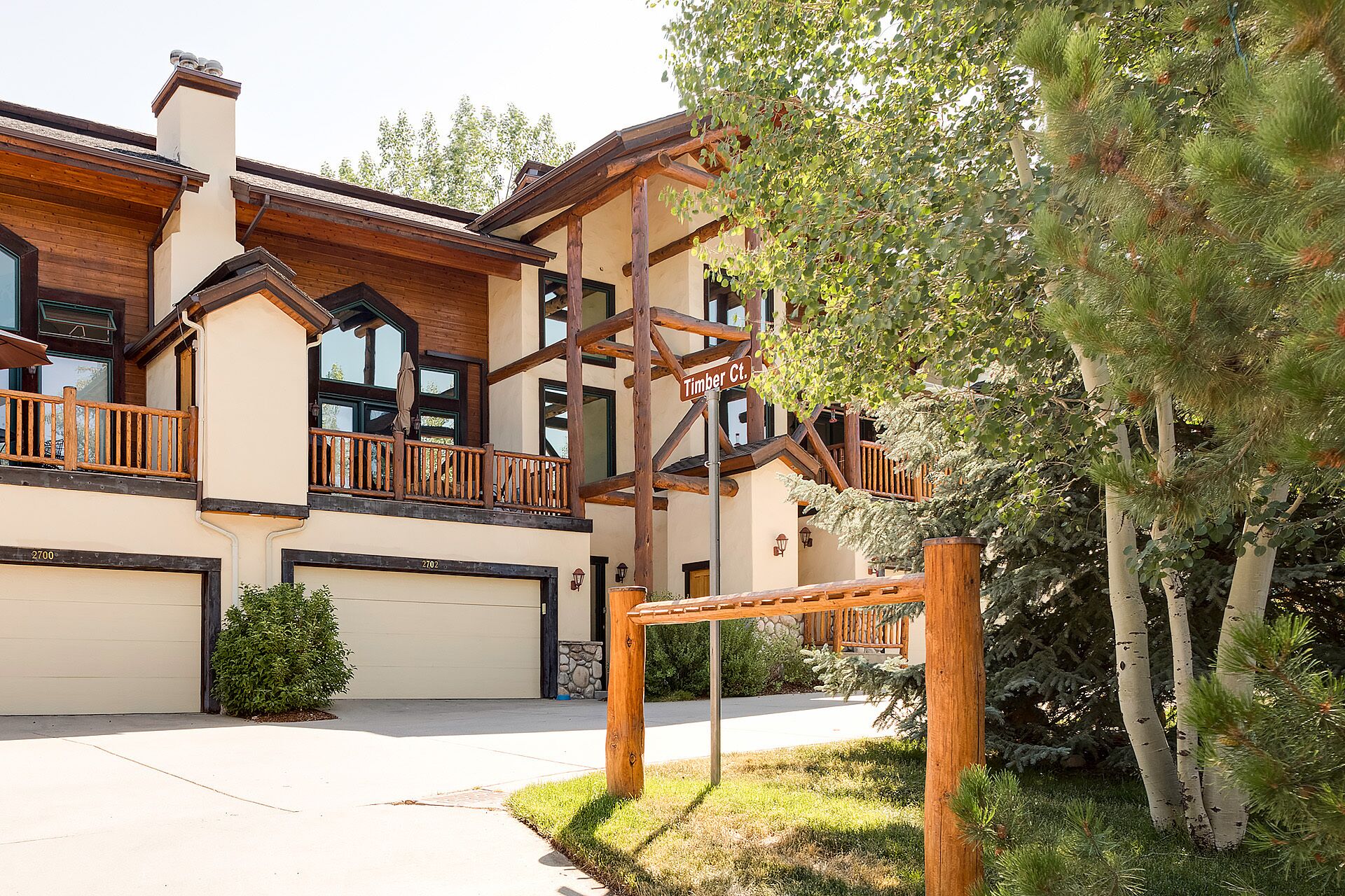 A two-story building with a wooden balcony and a garage.