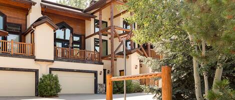A two-story building with a wooden balcony and a garage.