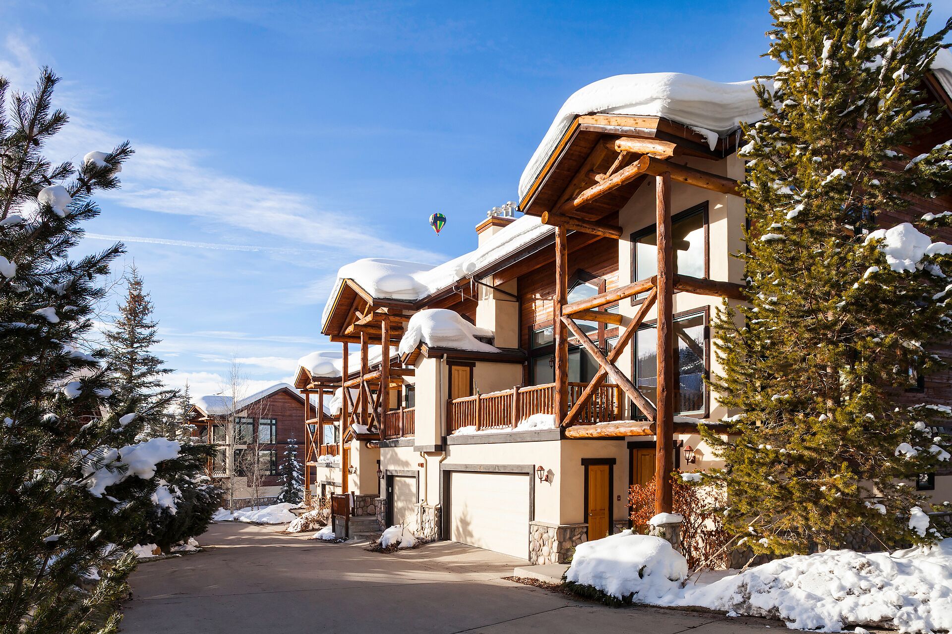 Ein schneebedecktes Chalet mit Holzfassade und einem Balkon.