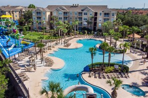 Un resort con una piscina grande, toboganes de agua y palmeras.