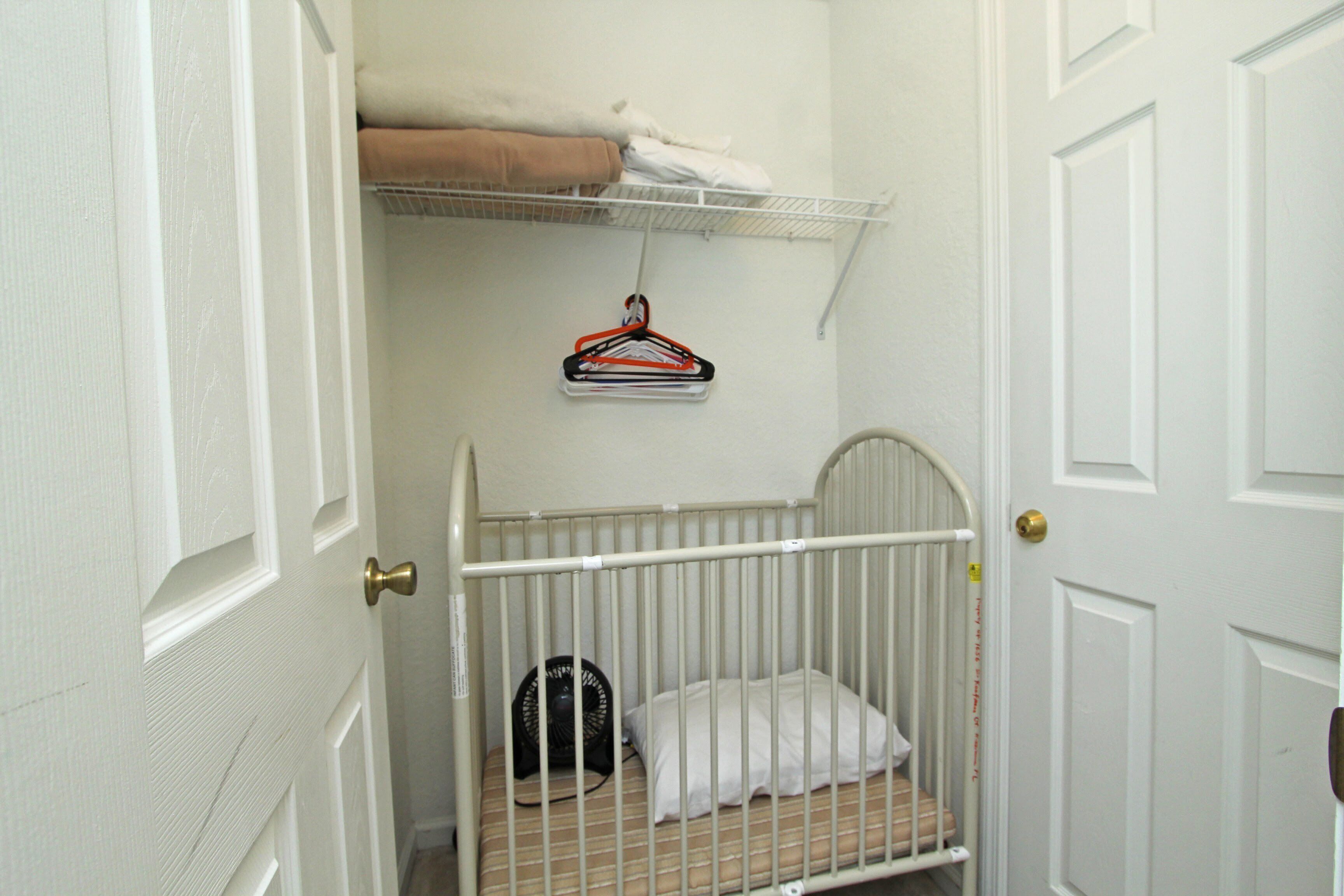 Ein kleines Zimmer mit einem weißen Einzelbett, einer weißen Tür, einer weißen Wand und einer weißen Decke.