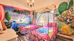 A bedroom with two beds, each with a canopy, and a mural on the wall depicting a princess.