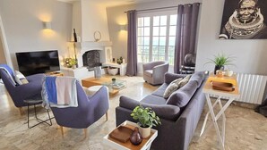 A modern living room with a grey sofa, armchairs, a coffee table, and a TV. - SUPERB VILLA (220m2), SEA AND VIEW BETWEEN ST MAXIME AND ISSAMBRES (Sainte-Maxime)