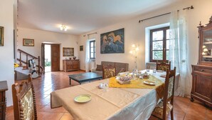Una sala da pranzo con un tavolo apparecchiato per quattro persone, una scala e un quadro appeso al muro.