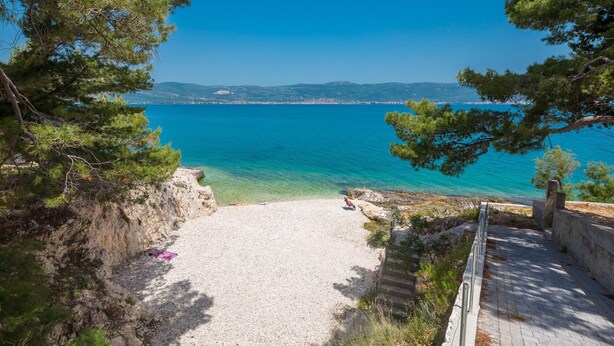 A coastal view with a clear sky, a sandy beach, and a distant shoreline. - Beachfront apartment with Infinity Pool & BBQ (Slatine)