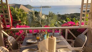 Mesa de comedor para cuatro personas con vista al mar y las colinas.