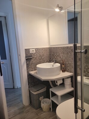 A bathroom with a white sink, a mirror, and patterned tiles on the walls. - VILLA PLUMBAGO (Porto Rotondo / Cugnana) (Olbia)