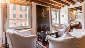 A room with white furniture, a dark table, and a painting on the wall. - Ca' Tintoretto (Venice)