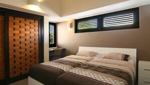 Un dormitorio con cama, escritorio y silla.