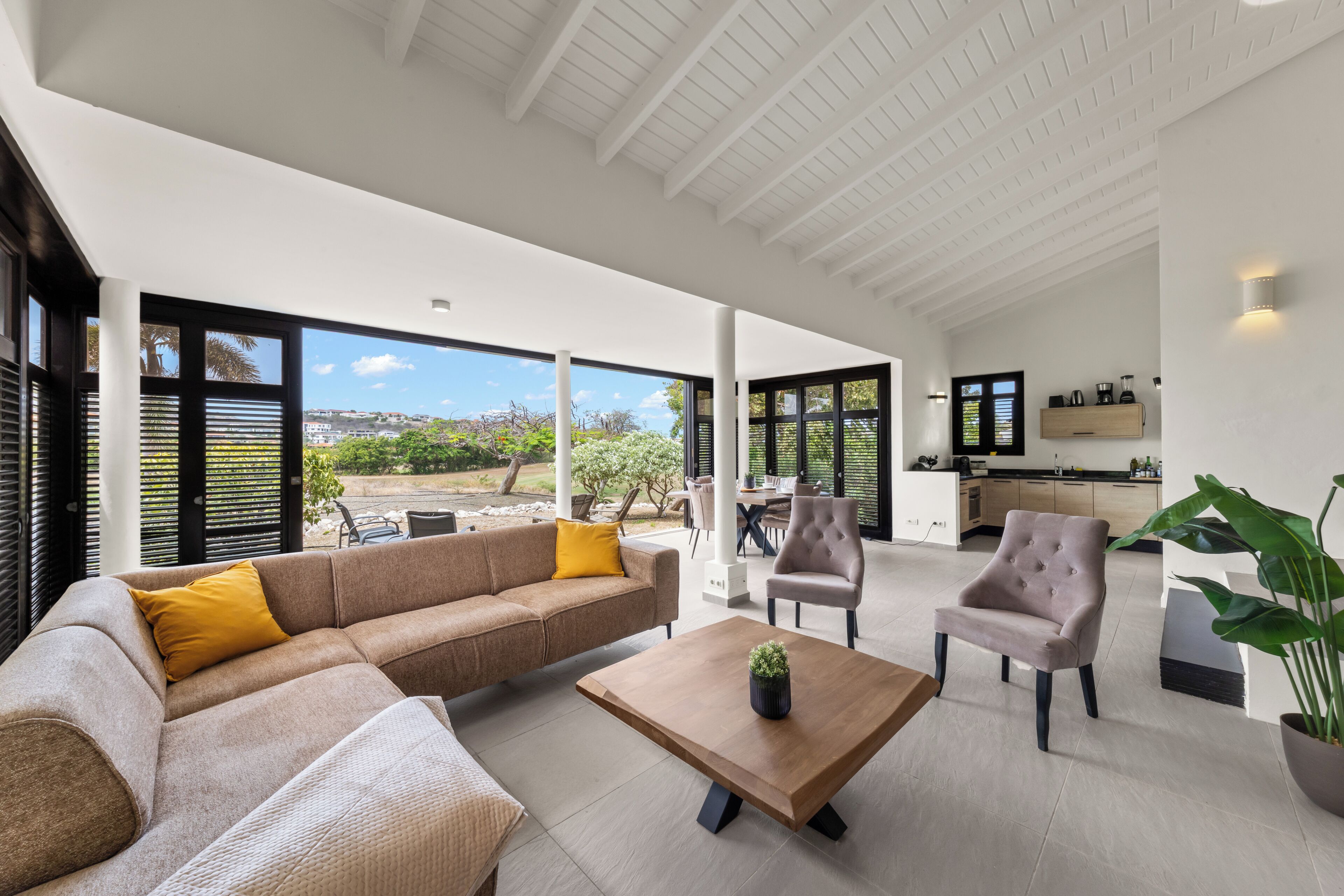 A spacious living area with a sofa, chairs, and a coffee table.
