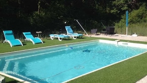 A swimming pool with blue lounge chairs and a grassy area. - On the edge of a forest, in green Provence, with private swimming pool (Brignoles)