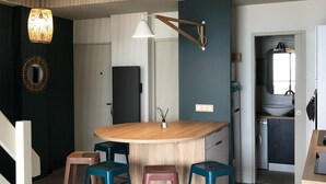 A modern kitchen with a central island, stools, and a hanging light fixture. - Magnificent 60m² apartment - 6 people with ocean view terrace South Beach  (Lacanau)