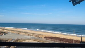 A beach view with a wooden fence, a sandy shore, and the ocean. - Magnificent 60m² apartment - 6 people with ocean view terrace South Beach  (Lacanau)