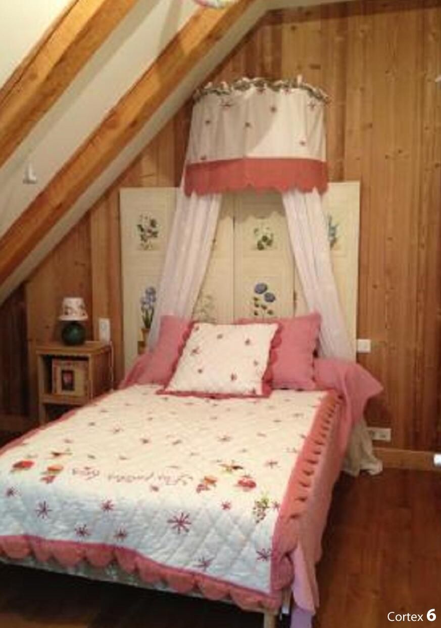 Une chambre à coucher avec un lit, une table de chevet et un plafond en bois.