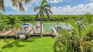 Un muelle con barcos, una piscina y abundante vegetación.