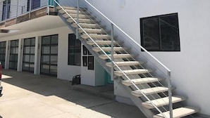A building with a staircase leading to a balcony, large windows, and a clean, modern design. - Steps to sand! Ocean view, Walk to village, family friendly, A/C! (Carlsbad)