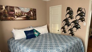 Ein Schlafzimmer mit Bett, Kissen, einem Gemälde und Wanddekoration.