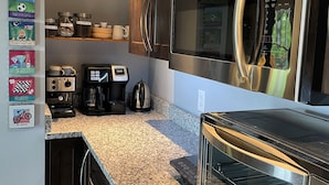 A modern kitchen with stainless steel appliances, granite countertops, and wooden cabinets. - King en suites.  Enjoy panoramic views of city and mountains, Walkable to town. (Asheville)