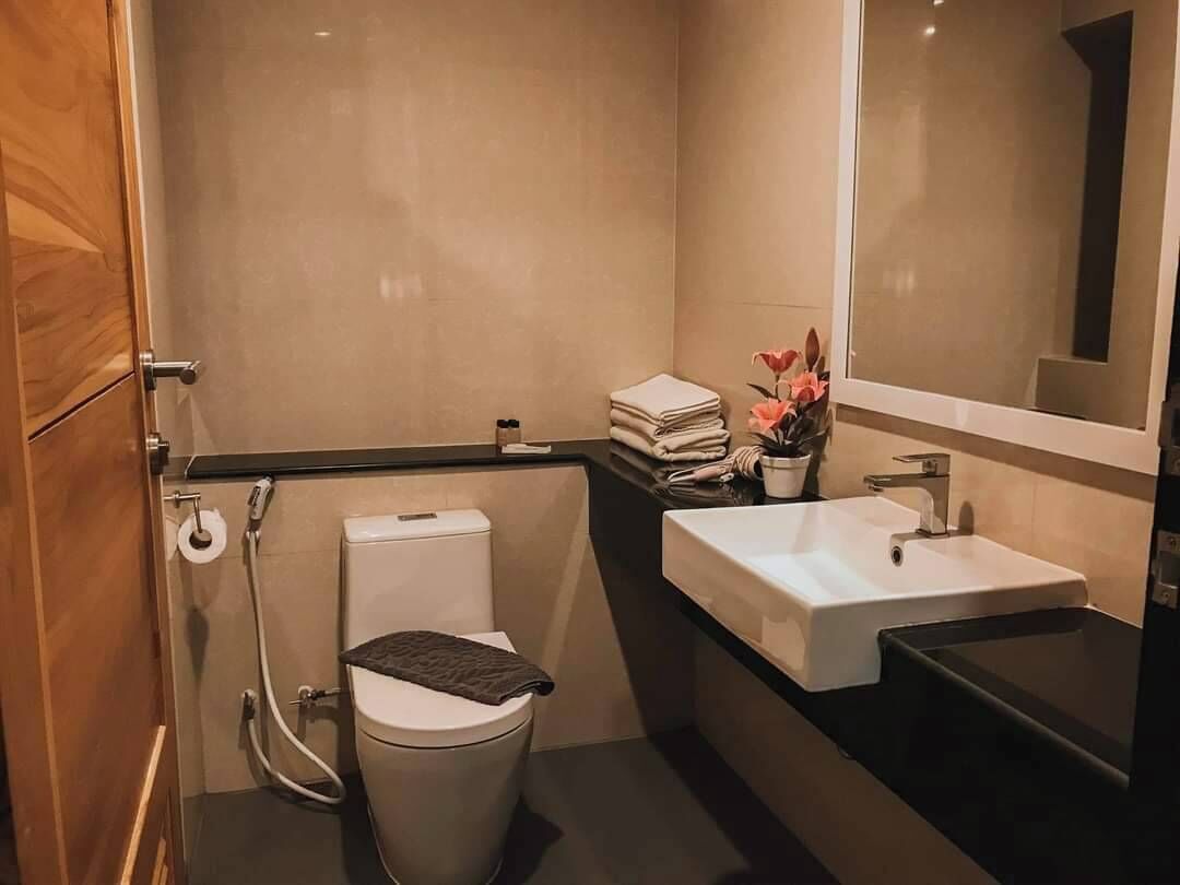 Une petite salle de bain comprenant des toilettes, un lavabo et un miroir.