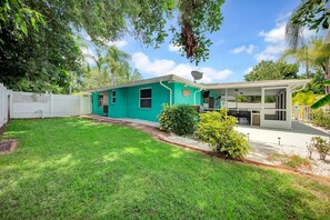 A two-story house with a green exterior, a covered patio, and a well-maintained lawn. - Tana’s Siesta Getaway - Heated Private Pool (Sarasota)