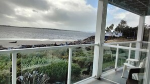 Un balcon avec vue sur la plage et l’océan.