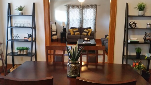 A dining area with a wooden table, chairs, and a central potted plant.