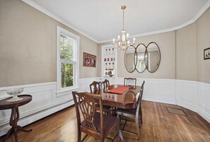 A dining room with a wooden table and chairs, a chandelier, and a large mirror on the wall. - Culp House: Ideal Location, Historic Gettysburg! Can Rent with the Cricket House (Gettysburg)