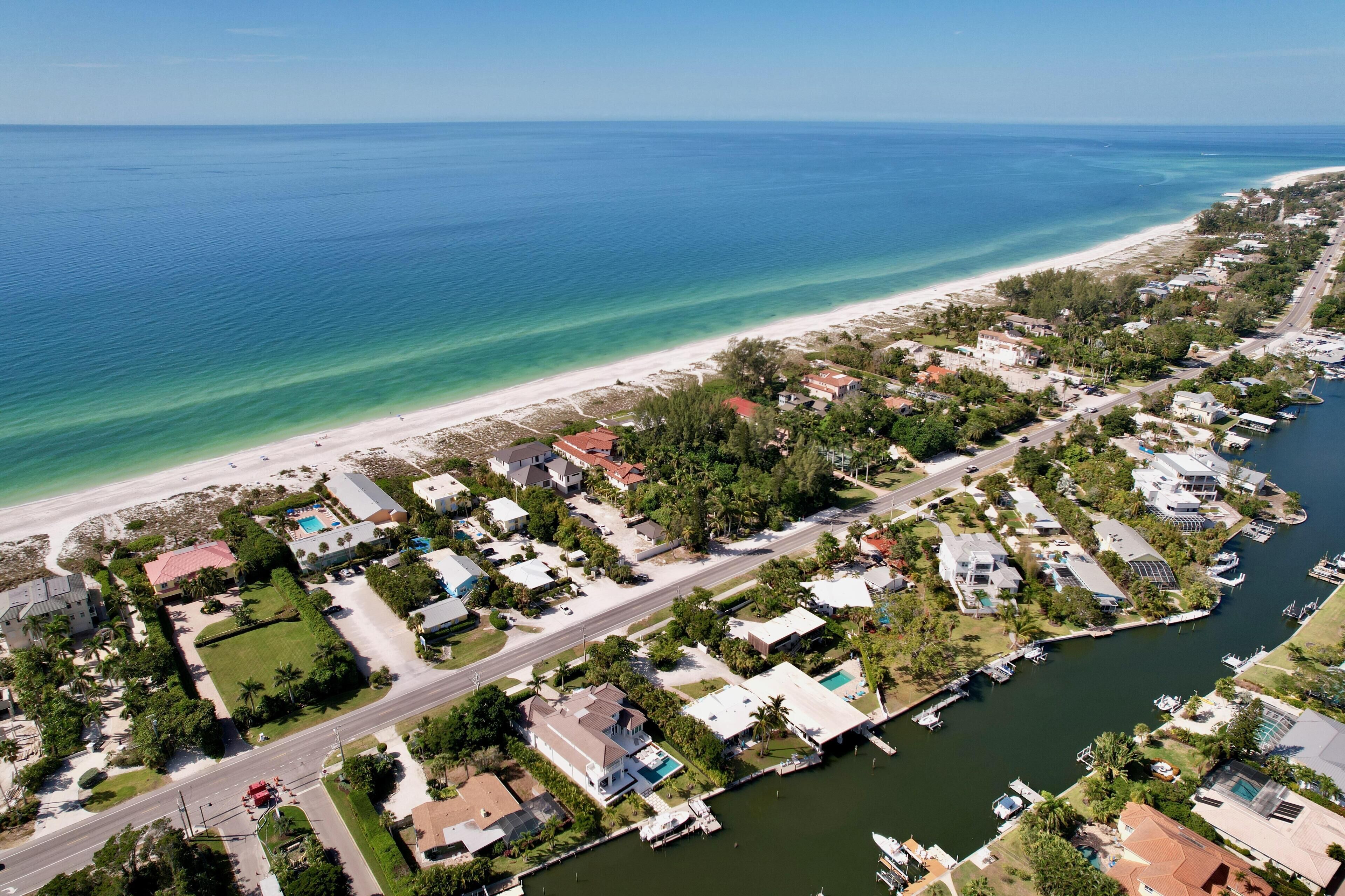 Vista aérea de una zona residencial costera con casas, un puerto deportivo y una playa.
