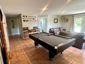 A pool table in a room with a sofa, chairs, and a door. - STAY HERE! Lake front home onsite boat launch and dock!BEAUTIFUL Views & Sunsets (Sevierville)