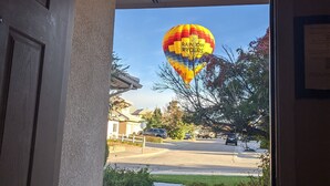 A view through a doorway to a street with a hot air balloon in the distance. - Outstanding Northeast Heights Home Near Casino/Golf/Breweries/Hiking/Dog Park (Albuquerque)