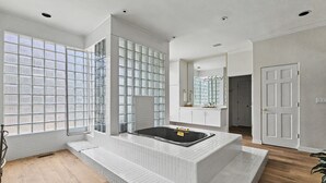 Un baño moderno con una bañera independiente, ventanas amplias y un diseño minimalista.