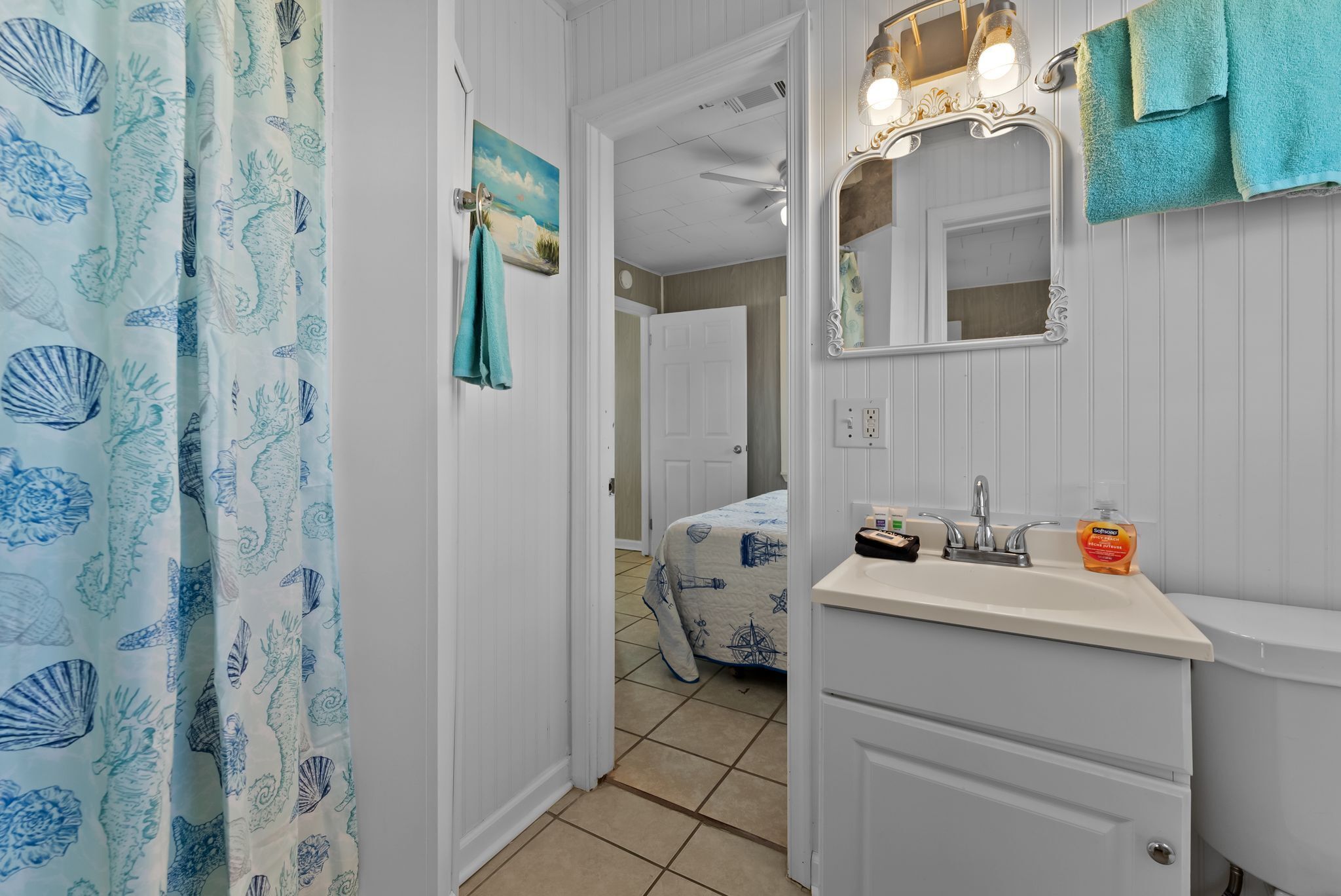 A bathroom with a sink, mirror, and towel rack.