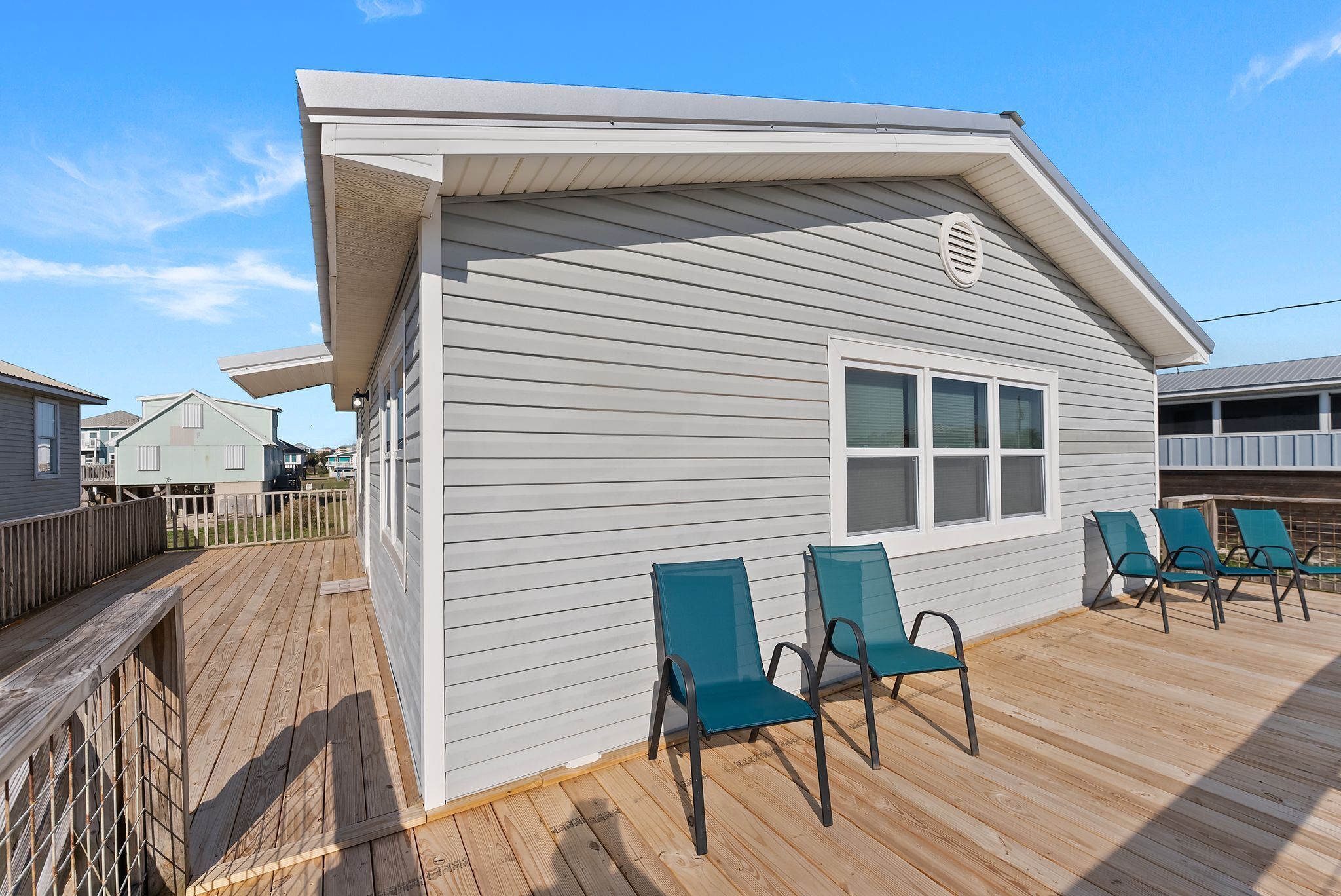 A house with a deck, two chairs, and a window.