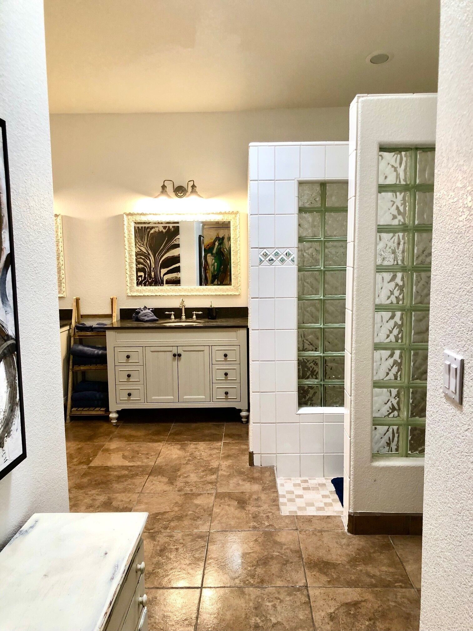 Un bagno con lavabo, specchio e pareti piastrellate.