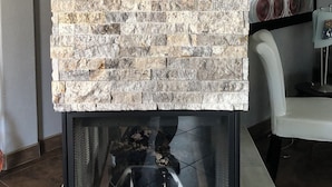 Un caminetto con rivestimento in pietra, un cartello di benvenuto e una scultura di orso polare.