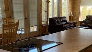 Une cuisine dotée d’un îlot central, de tabourets en bois, d’une table à manger avec des chaises et d’un canapé.