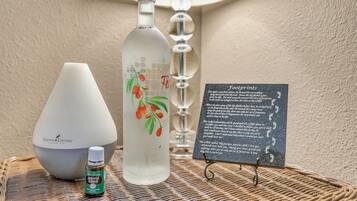 Une bouteille d’huiles essentielles Young Living, une bouteille en verre avec un bouchon rouge, un diffuseur blanc, un petit flacon d’huile essentielle d’eucalyptus et un panneau portant le titre « Empreintes ».