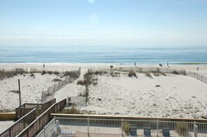 A beach with a wooden fence, a wooden walkway, and a few people walking. - Beautifully Remodeled! Affordable! 2 BR/2BA Cottage, A Great Vacation Spot! (Gulf Shores)