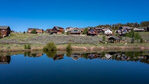 Un barrio residencial a orillas de un lago, con casas reflejadas en el agua.