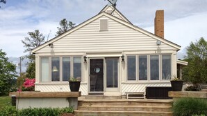 A single-story house with a front porch, large windows, and a chimney. -  Cottage on a Private Island in the York River (Gloucester Point)