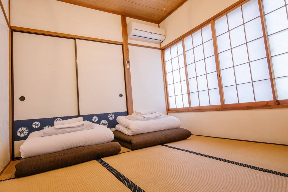 A traditional Japanese room with tatami mats, a shoji screen, and a sliding door.