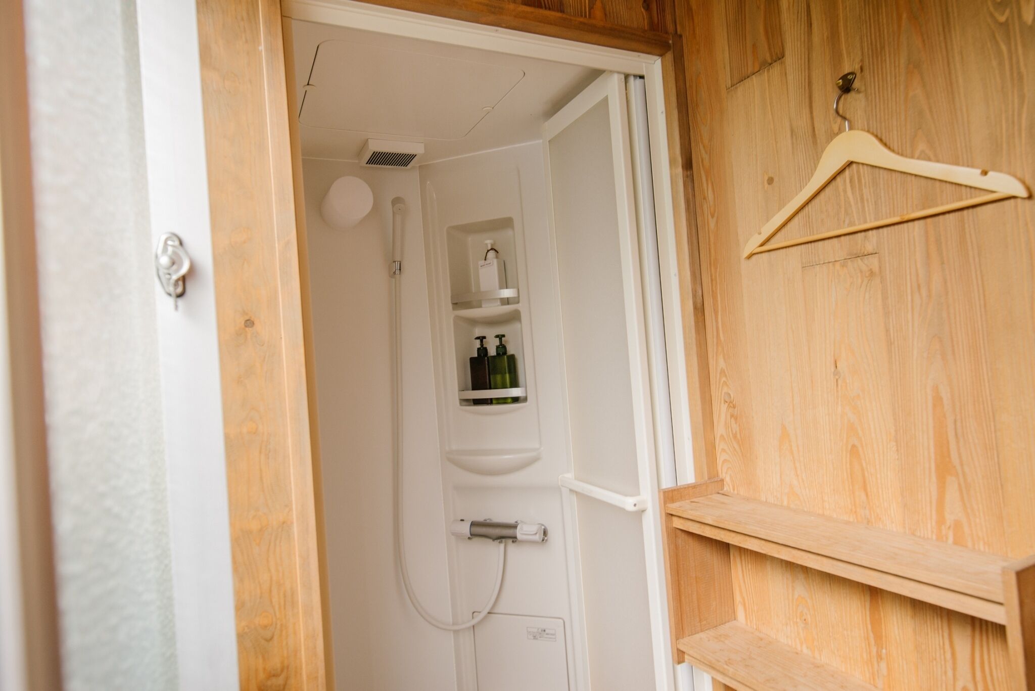 A wooden door with a hanging wooden hanger.
