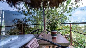 A balcony with a view of a mountainous landscape, a thatched roof, and a potted plant. - Eco Hills Homestay (Ta Van)
