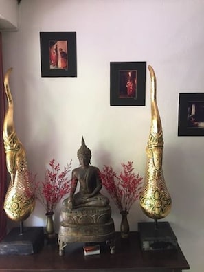A statue of a seated figure with two large golden objects on either side. - Fong Kaew and Baan Nang Fa Guesthouse (Patong)