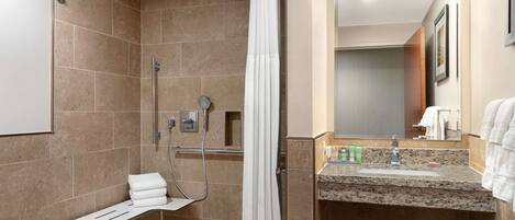 A modern bathroom with a shower, a vanity with a sink, and a mirror.