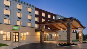 A modern hotel with a flat roof, large windows, and a covered entrance area. - Wyndham Garden State College (Boalsburg)