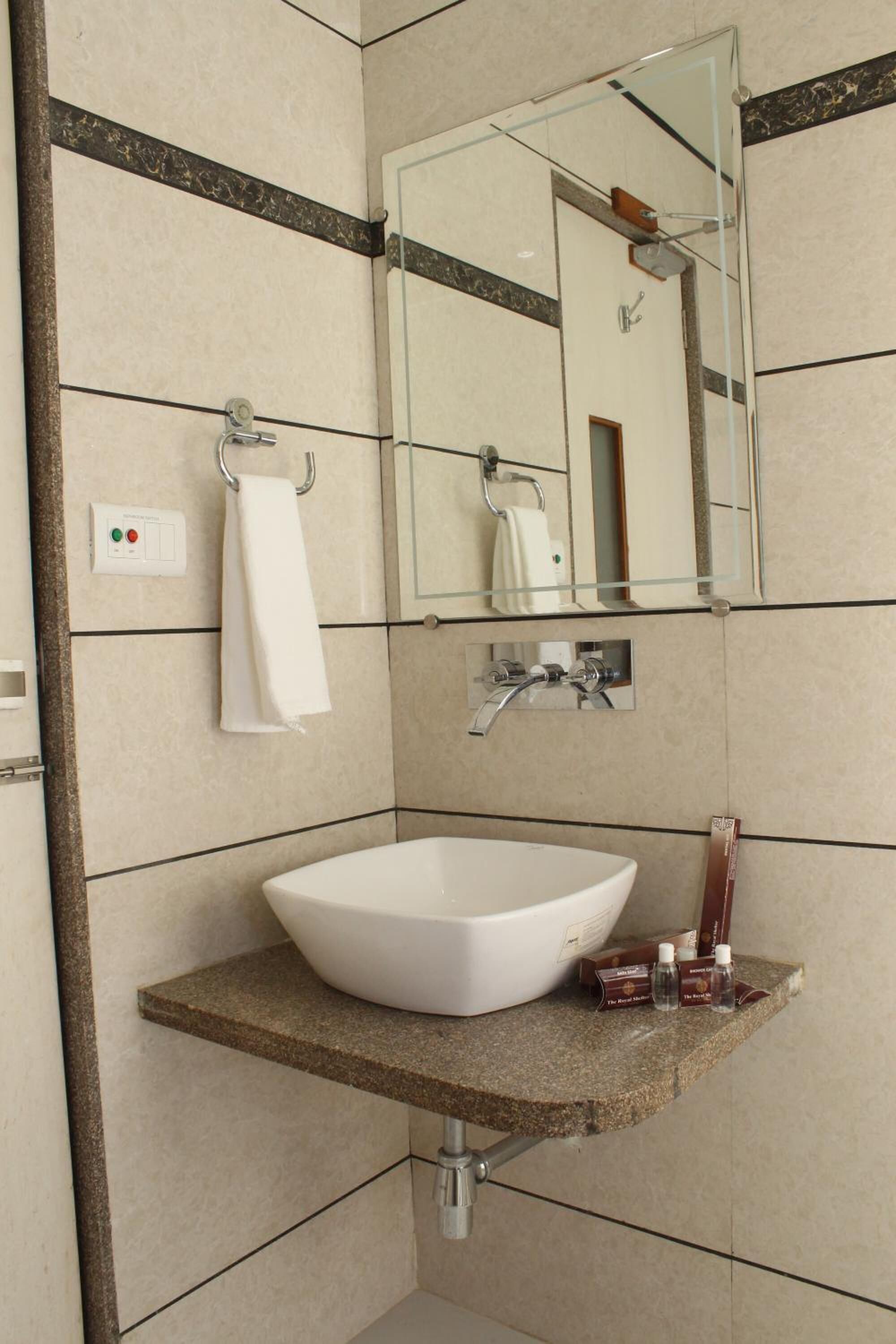 A bathroom with a white sink, a mirror, and a towel rack.