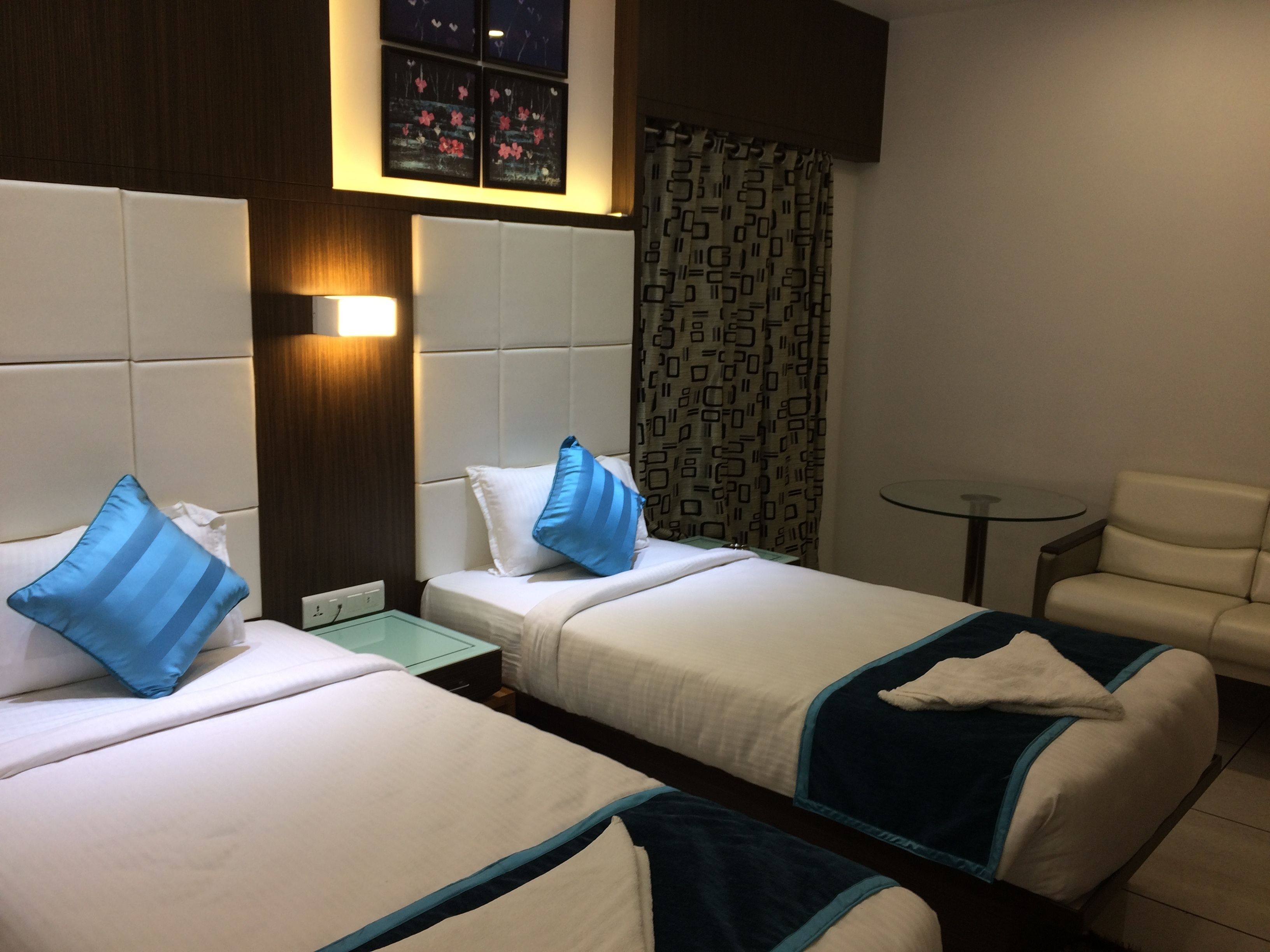 Una habitación de hotel con dos camas, una mesita y una silla.