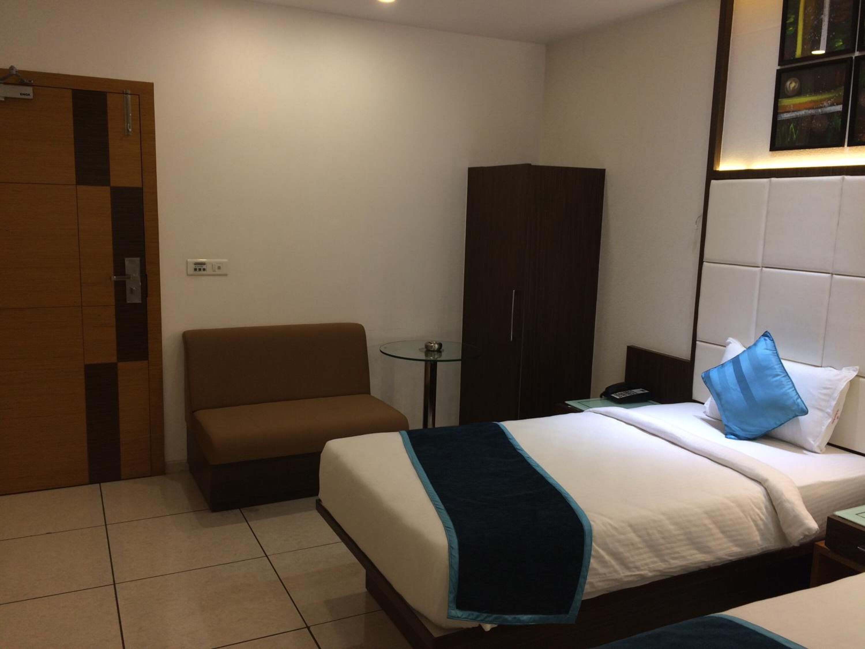 Ein Hotelzimmer mit Bett, einer Couch, einem Kleiderschrank und einem kleinen Tisch.