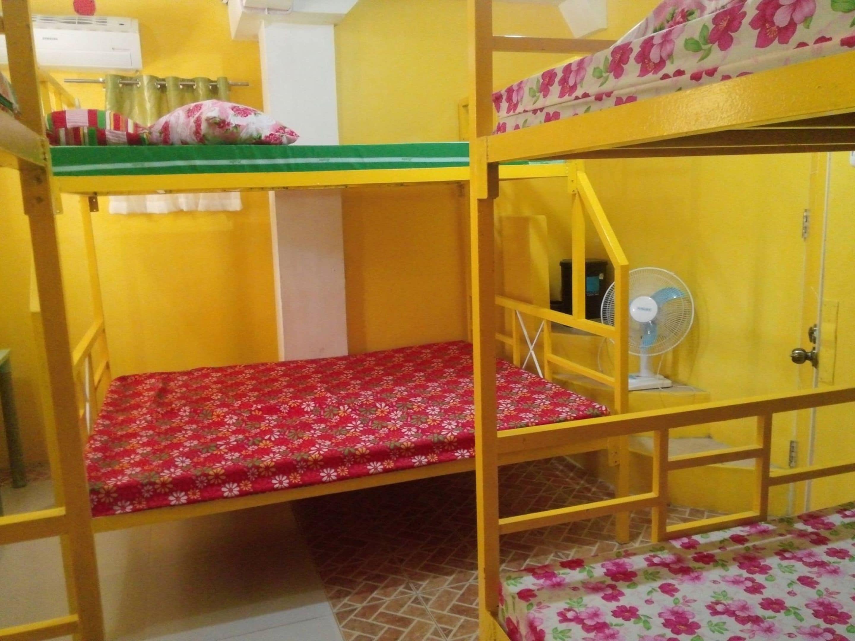 Dormitorio con literas, un ventilador y una puerta.